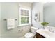 This powder room features a white toilet, single sink vanity, neutral paint, and a window offering natural light at 315 Copper Ridge Dr, Sanford, NC 27330