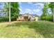 View of the rear exterior featuring a porch and a backyard surrounded by lush greenery, creating a serene atmosphere at 315 Copper Ridge Dr, Sanford, NC 27330
