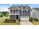 Charming two-story home featuring stone accents, a balcony, and a two-car garage at 316 Barley Mill Rd, Holly Springs, NC 27540