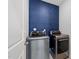 Laundry room showcasing modern washer and dryer against a striking blue accent wall at 316 Barley Mill Rd, Holly Springs, NC 27540
