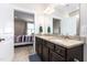 Bathroom showcasing double sink vanity with granite countertop, dark wood cabinets, and an entrance to the bedroom at 3248 Castlerock Dr, Burlington, NC 27215