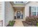 Close-up view of the home's entryway, featuring a dark-stained door, landscaping, and charming details at 3248 Castlerock Dr, Burlington, NC 27215