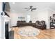 Bright living room featuring hardwood floors and a round area rug, a fireplace, ceiling fan, and comfortable seating at 3248 Castlerock Dr, Burlington, NC 27215