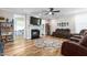 Bright living room featuring a fireplace, ceiling fan, hardwood floors and comfortable brown reclining sofas at 3248 Castlerock Dr, Burlington, NC 27215