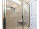 Bathroom shower featuring glass door, tiled walls, corner seat and shower niche for storage at 3248 Castlerock Dr, Burlington, NC 27215