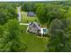 Aerial view of a home featuring an in-ground pool and beautiful landscaping, nestled in a lush, green setting at 325 Forest Bridge Rd, Youngsville, NC 27596