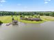 Panoramic aerial view of the lakefront estate with boat dock, main house, and lush landscape at 325 Forest Bridge Rd, Youngsville, NC 27596
