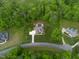 Aerial view showcases a private backyard oasis complete with a sparkling pool, lush landscaping, and ample greenery at 325 Forest Bridge Rd, Youngsville, NC 27596