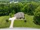 Stunning aerial view of a grand home with lush green lawn surrounded by dense trees at 325 Forest Bridge Rd, Youngsville, NC 27596