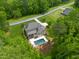 Aerial view showcases a private backyard oasis complete with a sparkling pool, lush landscaping, and ample greenery at 325 Forest Bridge Rd, Youngsville, NC 27596