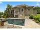 Exterior shot of the house from the backyard with a pool, patio, and lush landscaping at 325 Forest Bridge Rd, Youngsville, NC 27596