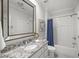 Bright bathroom features granite vanity, framed mirror, and tiled shower with blue curtain at 325 Forest Bridge Rd, Youngsville, NC 27596