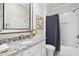 Bathroom featuring a vanity with a granite countertop, decorative mirror, and a shower-tub with gray curtain at 325 Forest Bridge Rd, Youngsville, NC 27596