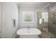 Bathroom featuring a soaking tub, walk-in shower, and a window with natural light at 325 Forest Bridge Rd, Youngsville, NC 27596