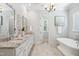 Elegant bathroom with dual vanity, soaking tub, and chandelier at 325 Forest Bridge Rd, Youngsville, NC 27596