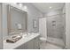 Bright bathroom with marble floors, gray vanity, and tiled walk-in shower at 325 Forest Bridge Rd, Youngsville, NC 27596
