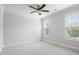 Neutral bedroom featuring carpeted floors, a ceiling fan, base trim, and natural light from two windows at 325 Forest Bridge Rd, Youngsville, NC 27596
