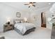 Neutral bedroom with decorative mirror, ceiling fan, and adjoining staircase at 325 Forest Bridge Rd, Youngsville, NC 27596