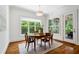 Bright dining room with hardwood floors, a wooden table and chairs, and large windows overlooking greenery at 325 Forest Bridge Rd, Youngsville, NC 27596