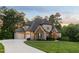 Exterior daytime view of a home with a two-car garage, stone accents, and manicured lawn at 325 Forest Bridge Rd, Youngsville, NC 27596