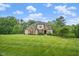 Beautiful two-story home showcasing a large, well-manicured lawn and a classic stone and siding exterior at 325 Forest Bridge Rd, Youngsville, NC 27596