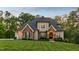 Exterior view of home featuring a stone facade, well-maintained lawn, and classic architectural details at 325 Forest Bridge Rd, Youngsville, NC 27596