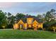 Home with stone facade and three car garage, with a beautifully maintained lawn and driveway at 325 Forest Bridge Rd, Youngsville, NC 27596