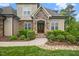 Charming front entrance with stone accents, double doors, and lush, colorful landscaping at 325 Forest Bridge Rd, Youngsville, NC 27596