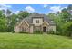 Beautiful stone and siding home with manicured lawn and mature trees on a sunny day at 325 Forest Bridge Rd, Youngsville, NC 27596