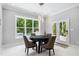 Bright game room with a dark game table, modern lighting, and outdoor views from the oversized window and door at 325 Forest Bridge Rd, Youngsville, NC 27596
