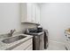 Functional laundry room featuring gray washer/dryer and granite countertop at 325 Forest Bridge Rd, Youngsville, NC 27596