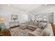 Open-concept living room with hardwood floors and seamless flow into kitchen area at 325 Forest Bridge Rd, Youngsville, NC 27596