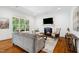 Inviting living room with a fireplace, large windows, hardwood floors, and comfortable seating arrangement at 325 Forest Bridge Rd, Youngsville, NC 27596