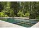Luxury pool with travertine decking, landscaping, and fire bowls at 325 Forest Bridge Rd, Youngsville, NC 27596
