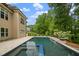 Outdoor pool with hot tub and a lush backyard for entertaining on a sunny day at 325 Forest Bridge Rd, Youngsville, NC 27596