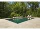 Luxury pool with travertine decking, landscaping, and lounge chairs at 325 Forest Bridge Rd, Youngsville, NC 27596