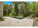 Beautiful backyard pool with a sun deck, luxurious travertine tile, and lush landscaping at 325 Forest Bridge Rd, Youngsville, NC 27596