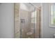 Modern shower with frameless glass door, tiled walls, and convenient shelving niche at 325 Forest Bridge Rd, Youngsville, NC 27596