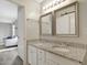 Bathroom featuring double sinks with granite countertop and decorative mirrors adjacent to a cozy living area at 3613 Ranbir Dr, Durham, NC 27713
