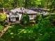 Aerial view of the home surrounded by mature trees, a well-manicured lawn, and lush landscaping at 3804 Nottaway Rd, Durham, NC 27707