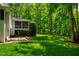 Large backyard with lush landscaping and mature trees and a view of screened in porch at 3804 Nottaway Rd, Durham, NC 27707