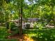 View of the exterior featuring lush landscaping and a backyard deck with a screened porch at 3804 Nottaway Rd, Durham, NC 27707