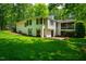 Beautifully landscaped backyard with well-maintained lawn and white brick home with dark shutters at 3804 Nottaway Rd, Durham, NC 27707
