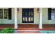 Elegant front entrance with a beautiful black double door and brick porch at 3804 Nottaway Rd, Durham, NC 27707