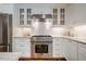 Well-lit kitchen features a stainless-steel range, white cabinets, white subway tile backsplash, and granite countertops at 3804 Nottaway Rd, Durham, NC 27707