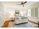 Elegant main bedroom with hardwood floors, a ceiling fan, and a cozy bed at 3804 Nottaway Rd, Durham, NC 27707