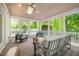 Inviting screened-in porch with wooden ceiling, skylight, ceiling fan, and comfortable seating area at 3804 Nottaway Rd, Durham, NC 27707