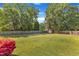 Spacious backyard with a storage shed, vibrant azalea bush, and surrounded by a wooden fence at 3909 Inland Ct, Raleigh, NC 27606