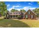 Charming brick home featuring a covered porch,dormer windows, and manicured landscaping at 3909 Inland Ct, Raleigh, NC 27606