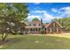 Charming brick home featuring a covered porch,dormer windows, and mature trees at 3909 Inland Ct, Raleigh, NC 27606